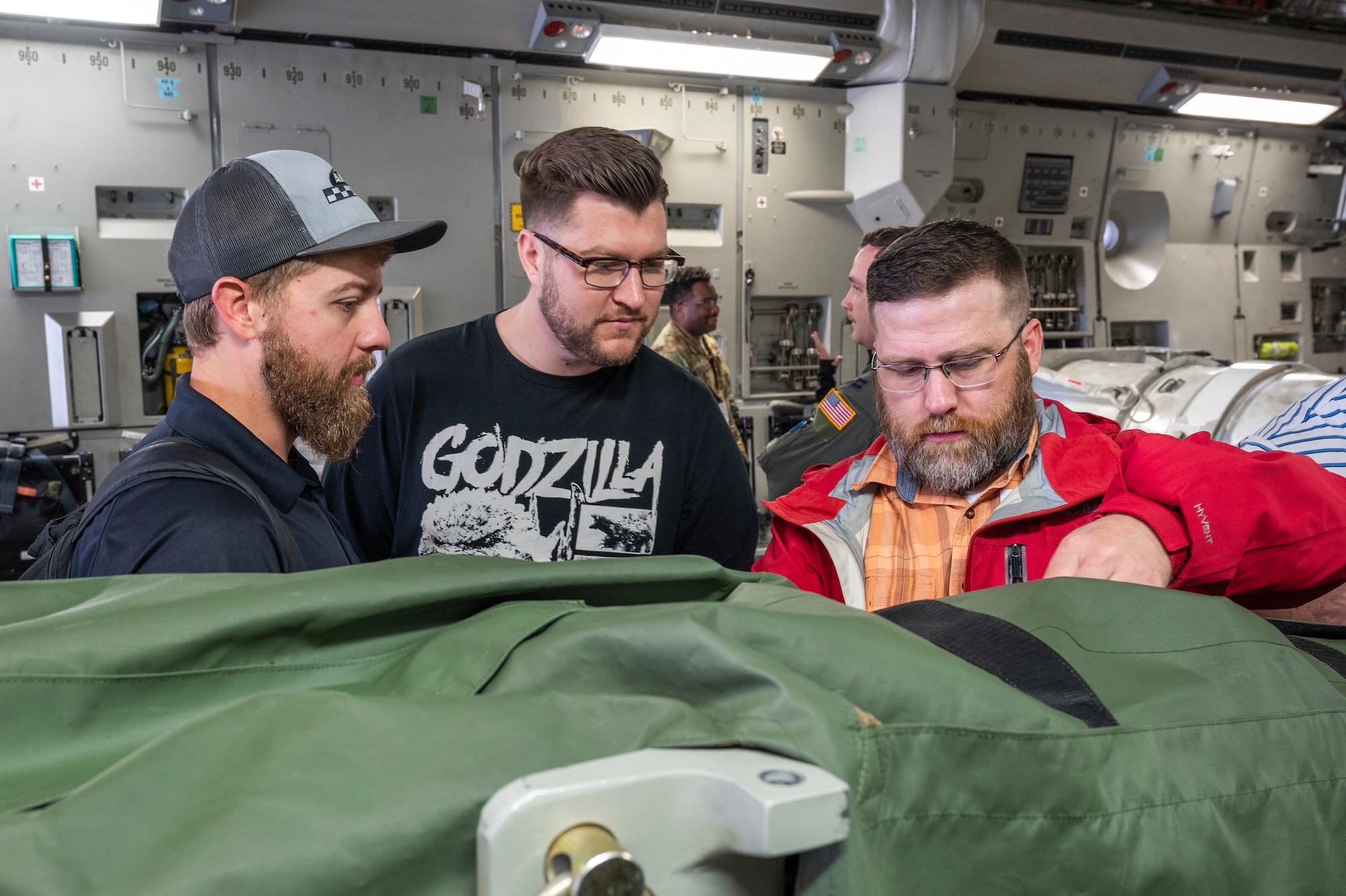 Three Sandia National Laboratories Weapon Intern Program participants inspect critical training items at Joint Base Lewis-McChord, Washington, May 7, 2025.