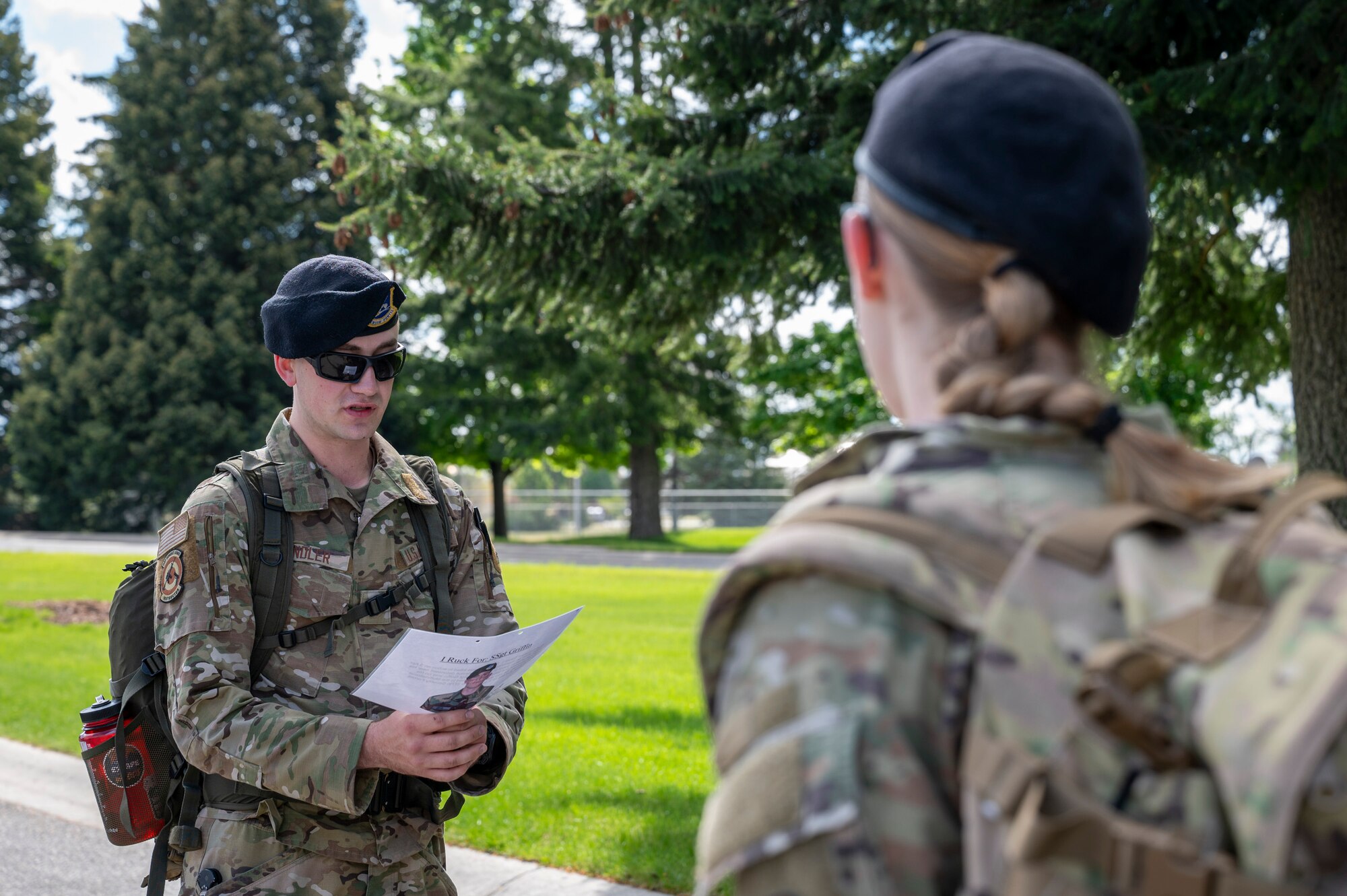U.S. Air Force Staff Sgt. Ryan Kindler, a combat arms instructor assigned to the 92nd Security Forces Squadron, reads a biography of a fallen soldier to commemorate their sacrifice during a Police Week Memorial Ruck at Fairchild Air Force Base, Washington, May 12, 2025. This four-mile memorial ruck honored all the fallen defenders, law enforcement officers, and Office of Special Investigations officers. (U.S. Air Force photo by Airman 1st Class Samantha Thorn).