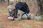 U.S. Air Force Airman 1st Class Payton Parent, a structural specialist with the 102nd Civil Engineer Squadron, assumes a prone position during a tactical ruck march on Otis Air National Guard Base, Massachusetts, May 2, 2025. The ruck march was part of Exercise Iron Nomad, a three-day, large-scale operation designed to simulate the rapid establishment of a forward operating location under simulated wartime conditions. (Air National Guard photo by Senior Airman Julia Ahaesy)