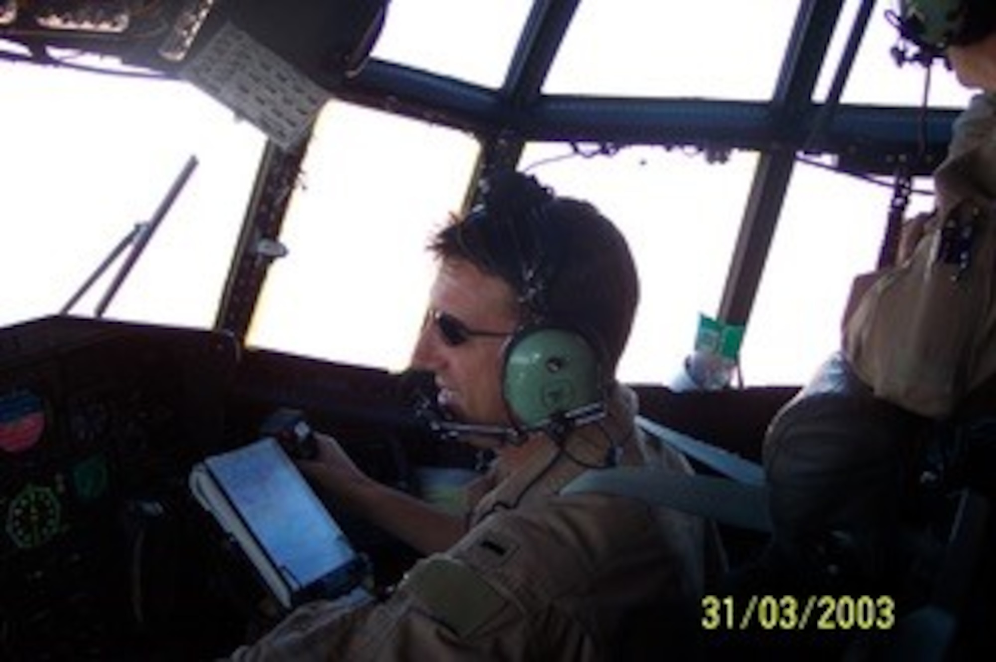 1st Lt.CJ Pfeil, flies a C-130 over the area of operation, during Operation Iraqi Freedom March 31, 2003. Photo is shot over the shoulder in the flight deck of a C-130