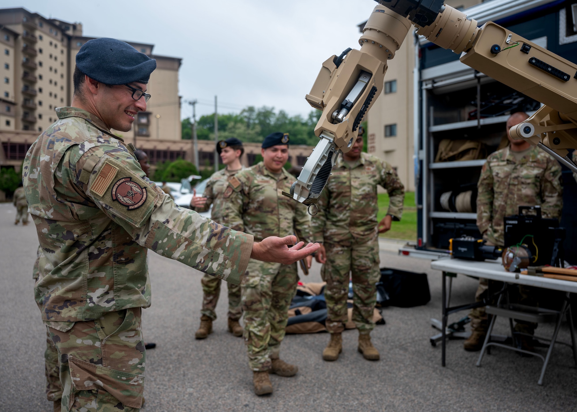 An L3 Harris T7 multi-mission robotic system hands a simulated grenade to U.S. Air Force Staff Sgt. Vincent Canazos, 51st Security Forces Squadron physical security non-commissioned officer in charge, during a Law Enforcement Display in recognition of 2025 National Police Week at Osan Air Base, Republic of Korea, May 15, 2025. The robotic system enhances operator safety and effectiveness across EOD, HAZMAT, and tactical response missions through advanced haptic controls and rugged mobility. (U.S. Air Force photo by Senior Airman Sarah Williams)