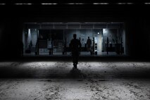 An Airman walks back down the range, silhouetted.