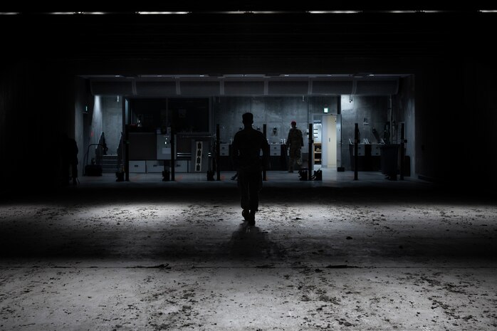 An Airman walks back down the range, silhouetted.