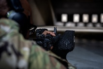 An Airman aims down the iron sight of an M4 carbine.