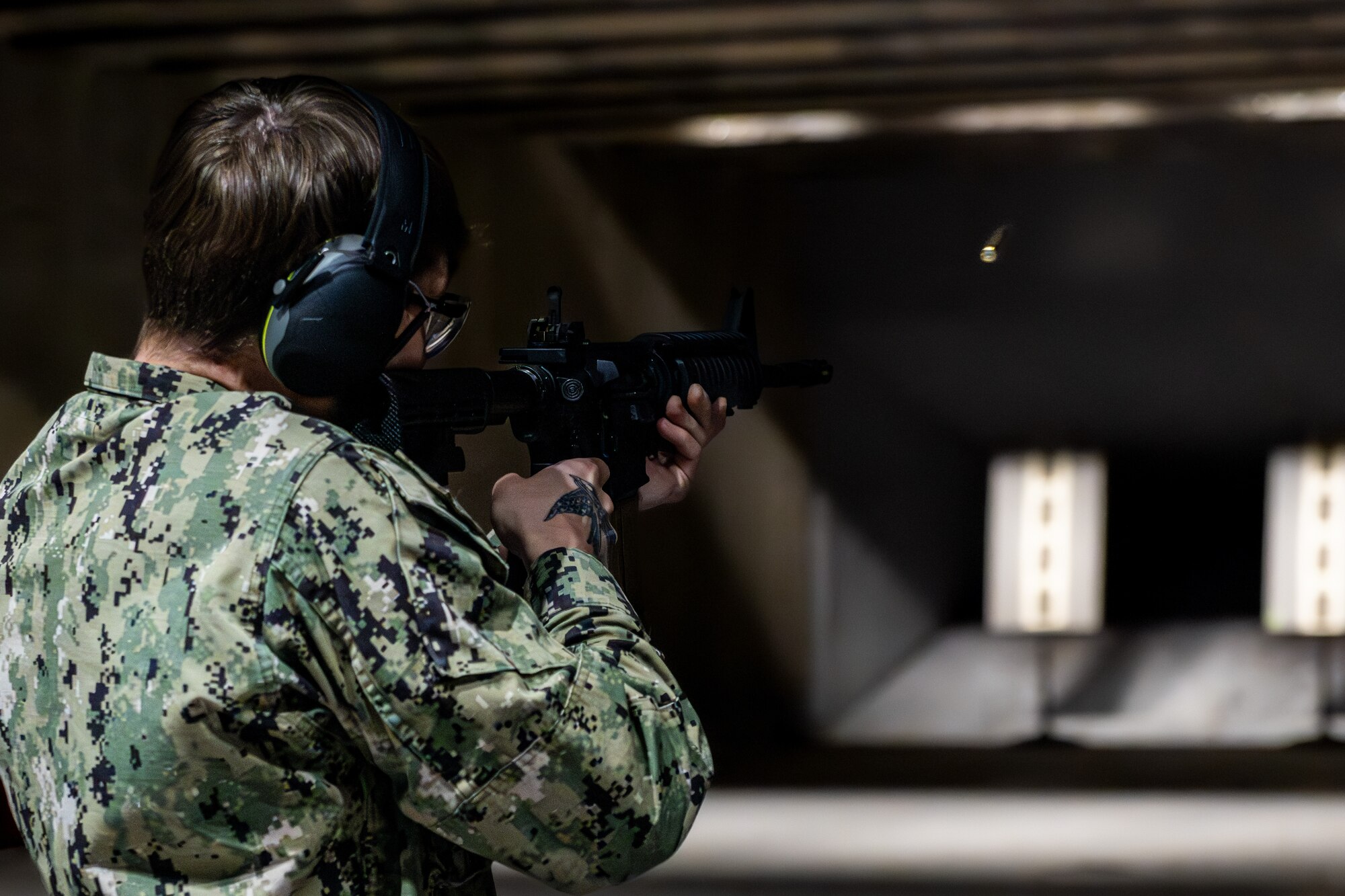 Sailor fires an M-4 carbine down range.