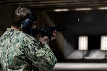 Sailor fires an M-4 carbine down range.