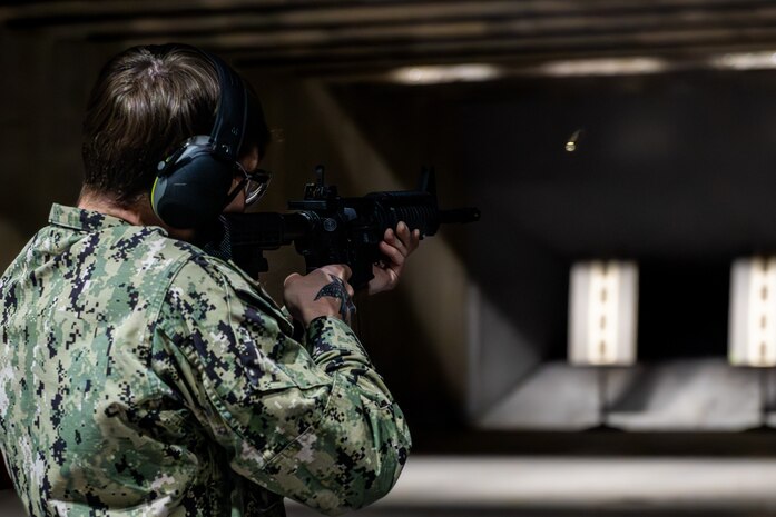 Sailor fires an M-4 carbine down range.