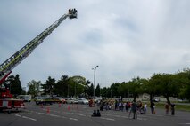 Attendees wait in line to ride a Misawa City Fire Department truck ladder during a Police Week demonstration.