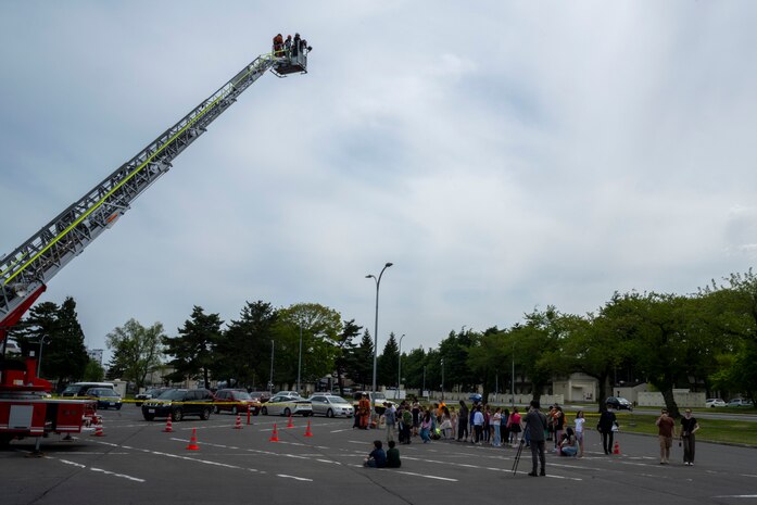 Attendees wait in line to ride a Misawa City Fire Department truck ladder during a Police Week demonstration.
