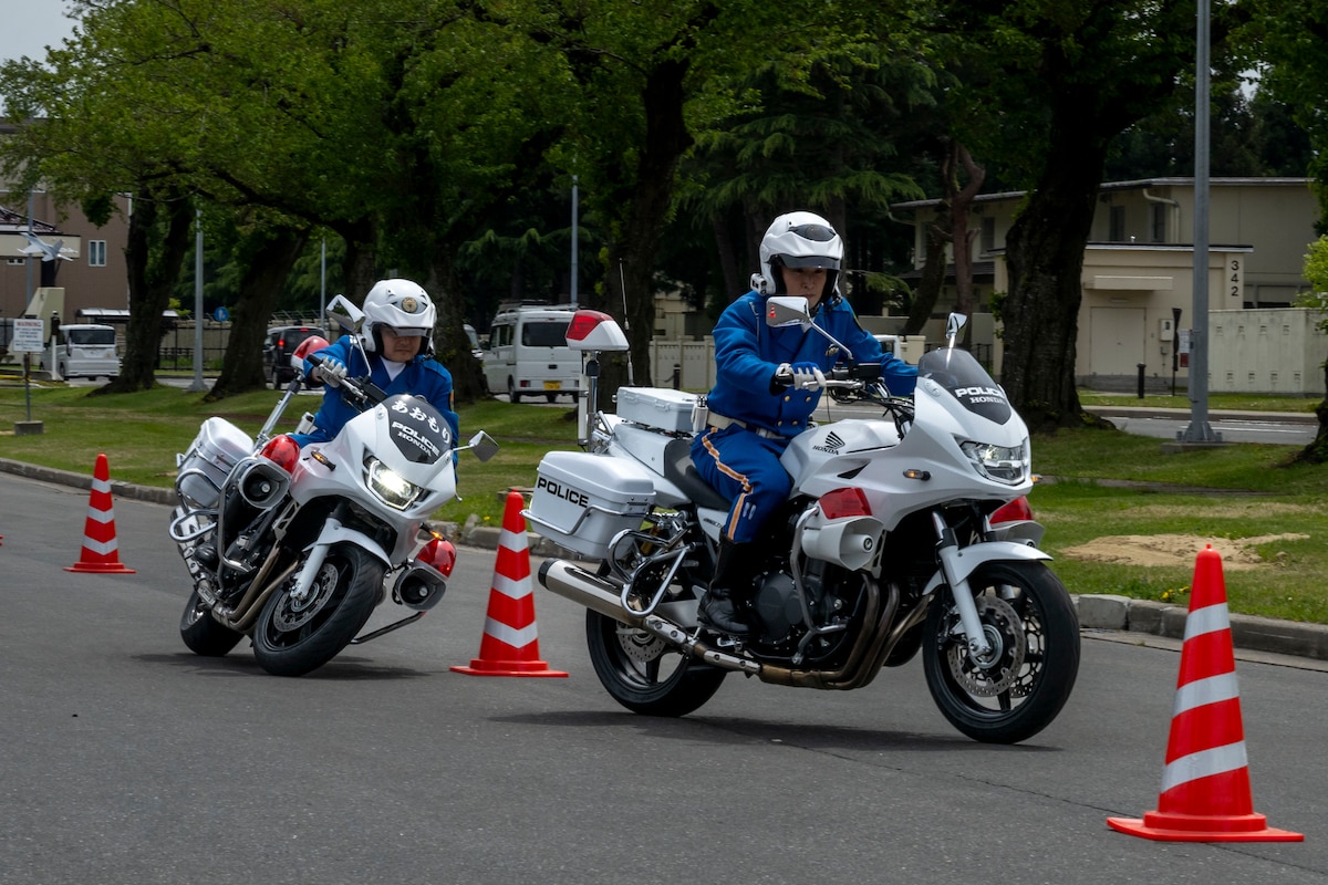 Aomori prefectural traffic mobile police unit officers weave between cones during a Police Week demonstration.