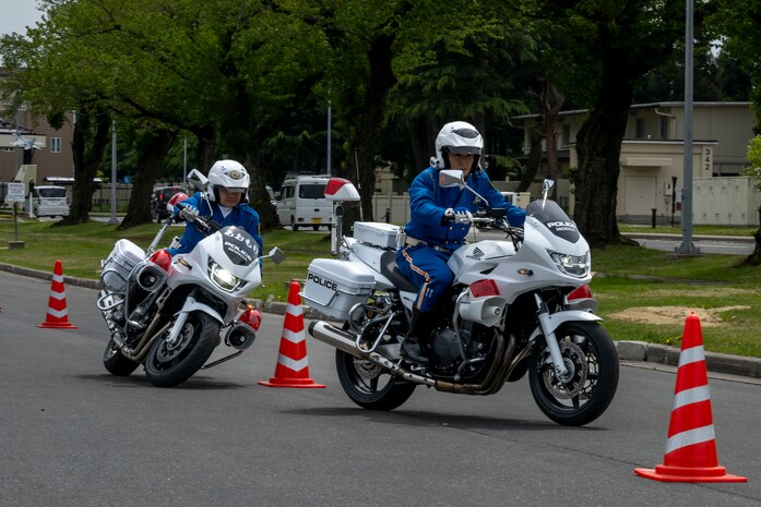 Aomori prefectural traffic mobile police unit officers weave between cones during a Police Week demonstration.