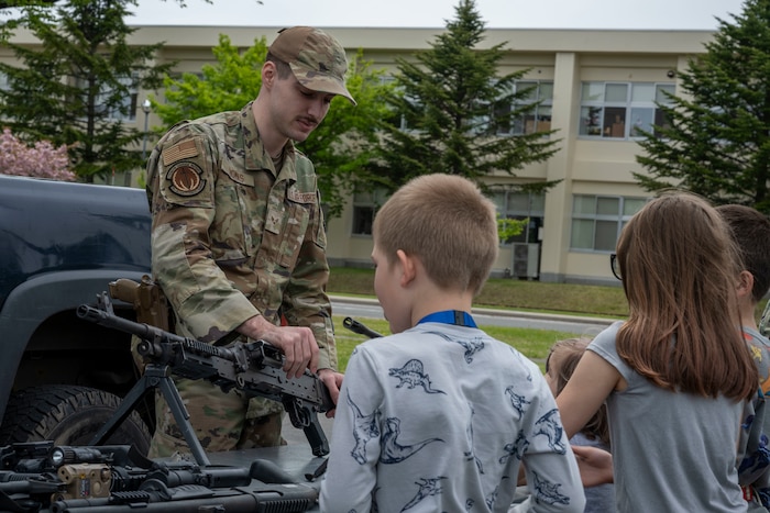 U.S. Air Force Senior Airman Ty Thomas, 35th Security Forces Squadron Defender, shows a variety of firearms employed by Security Forces to attendees during a Police Week demonstration.