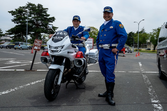 Aomori prefectural traffic mobile police unit officers pose with a motorcycle during a Police Week demonstration.