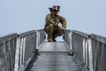 U.S. Air Force Staff Sgt. Thomas Hyde, 35th Civil Engineer Squadron firefighter, kneels at the top of a fire ladder during a Police Week demonstration.