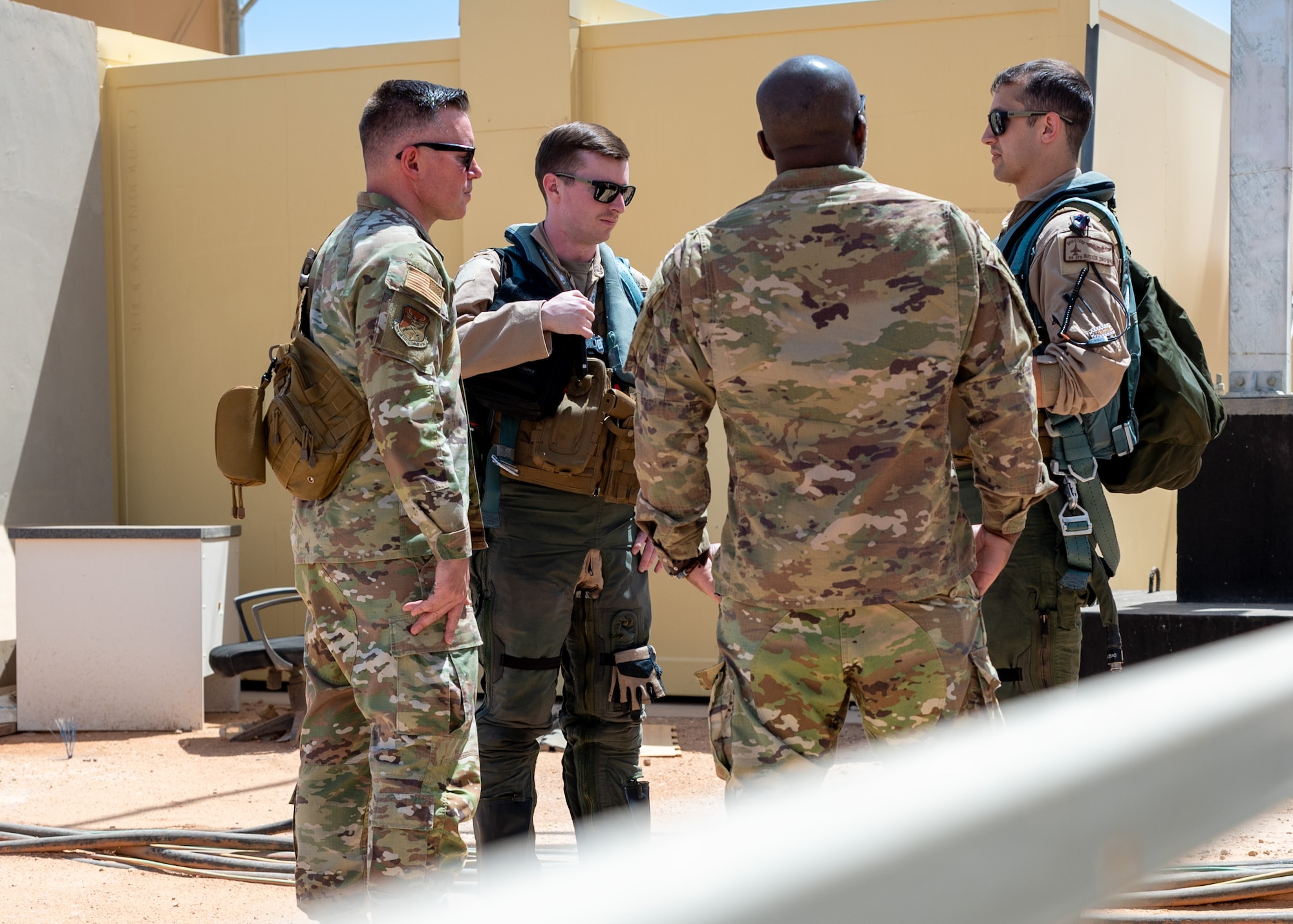 Two religious support team members talk with two F-16 pilots outside