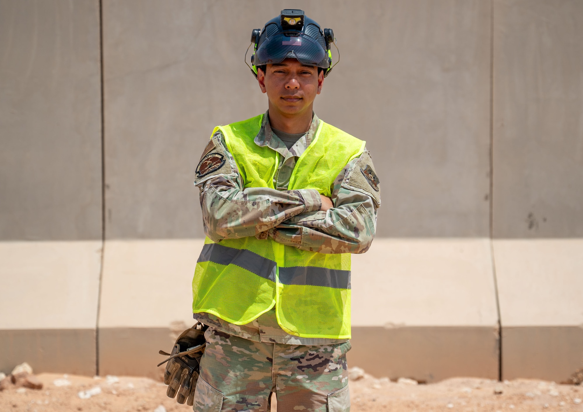 A man poses in front of a wall.