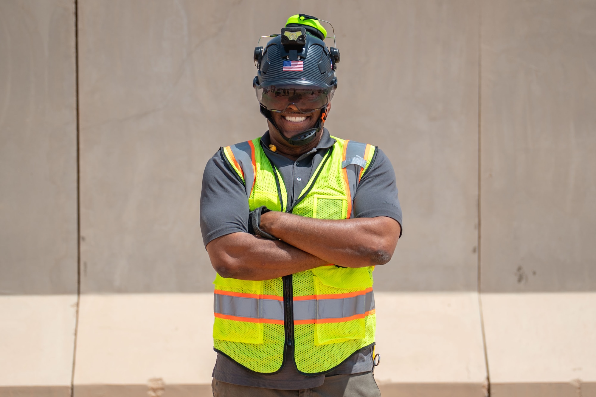 A man poses in front of a wall.