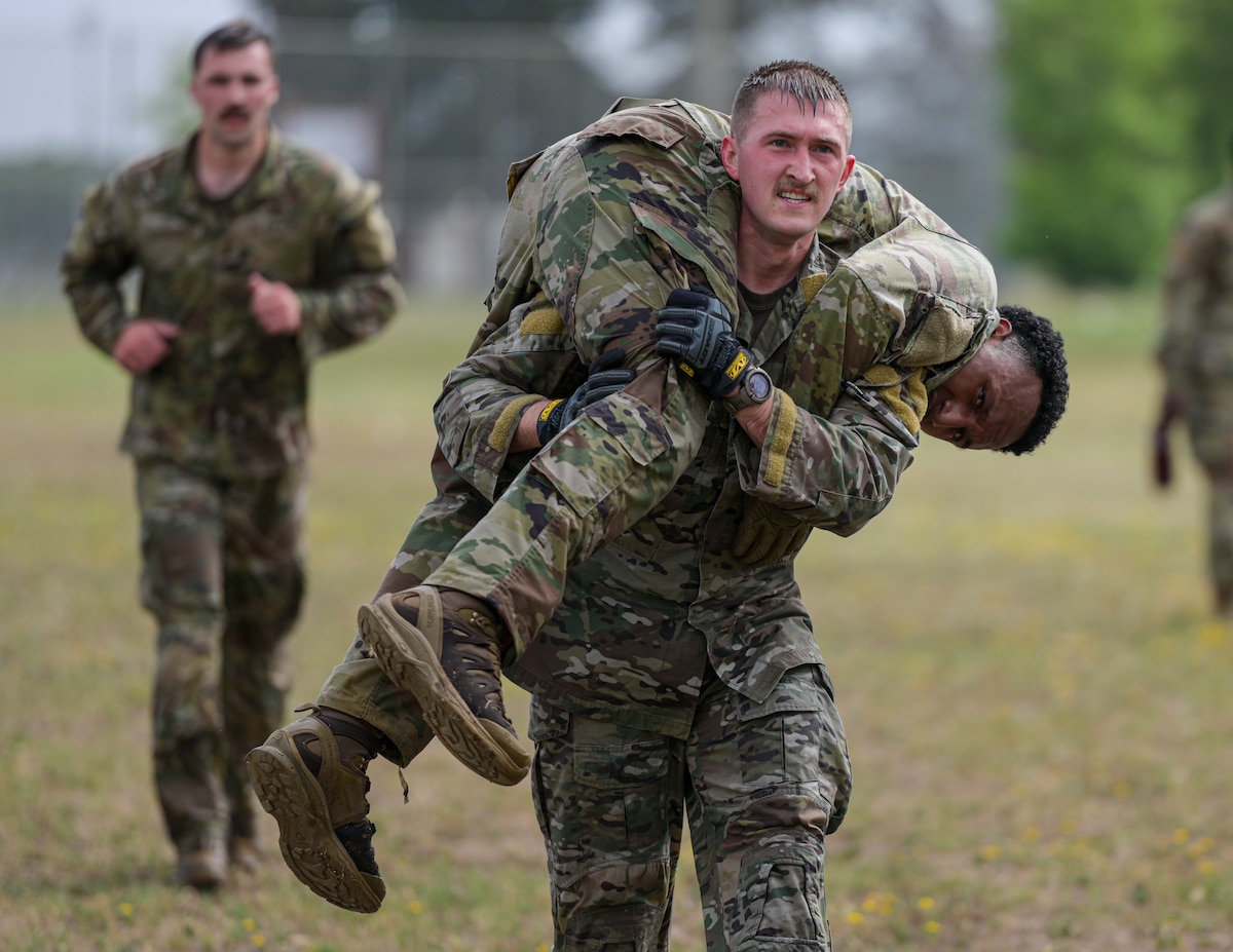 A U.S. Air Force Airman assigned to the 39th Security Forces Squadron carries a teammate during a fireman carry relay for the Defenders Challenge as part of National Police Week at Incirlik Air Base, Türkiye, May 13, 2025. The 39th SFS’s Defender Challenge brought Airmen together to compete in tactical and endurance events during Police Week, strengthening unit cohesion and operational effectiveness critical to U.S. Air Forces in Europe missions. (U.S. Air Force photo by Staff Sgt. Brieana E. Bolfing)
