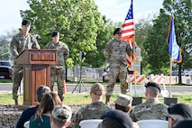 A speaker on a stage behind a podium speaking to many people