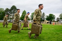 Four men carrying gas cans