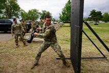An airman with a steel rod breaching a door