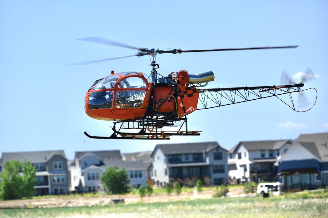 a red, scale, radio-controlled helicopter about to land