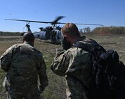 Airmen assigned to the 175th Wing, Maryland Air National Guard, prepare to board a HH-60W Jolly Green II helicopter during combat search and rescue training at the Hardwood Range, Wisconsin, May 12, 2025. The HH-60W Jolly Green II helicopter was part of the Combat Search and Rescue task force element during the week-long training. (U.S. Air National Guard photo by Senior Master Sgt. Chris Schepers)