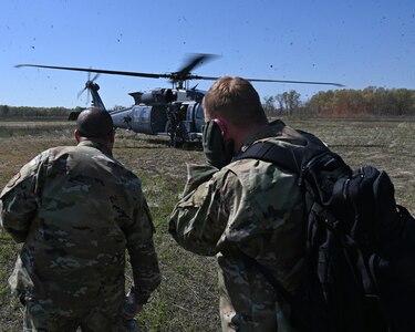 Airmen assigned to the 175th Wing, Maryland Air National Guard, prepare to board a HH-60W Jolly Green II helicopter during combat search and rescue training at the Hardwood Range, Wisconsin, May 12, 2025. The HH-60W Jolly Green II helicopter was part of the Combat Search and Rescue task force element during the week-long training. (U.S. Air National Guard photo by Senior Master Sgt. Chris Schepers)