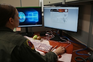 Airman sits at computer to fill in online form for legal assistance.
