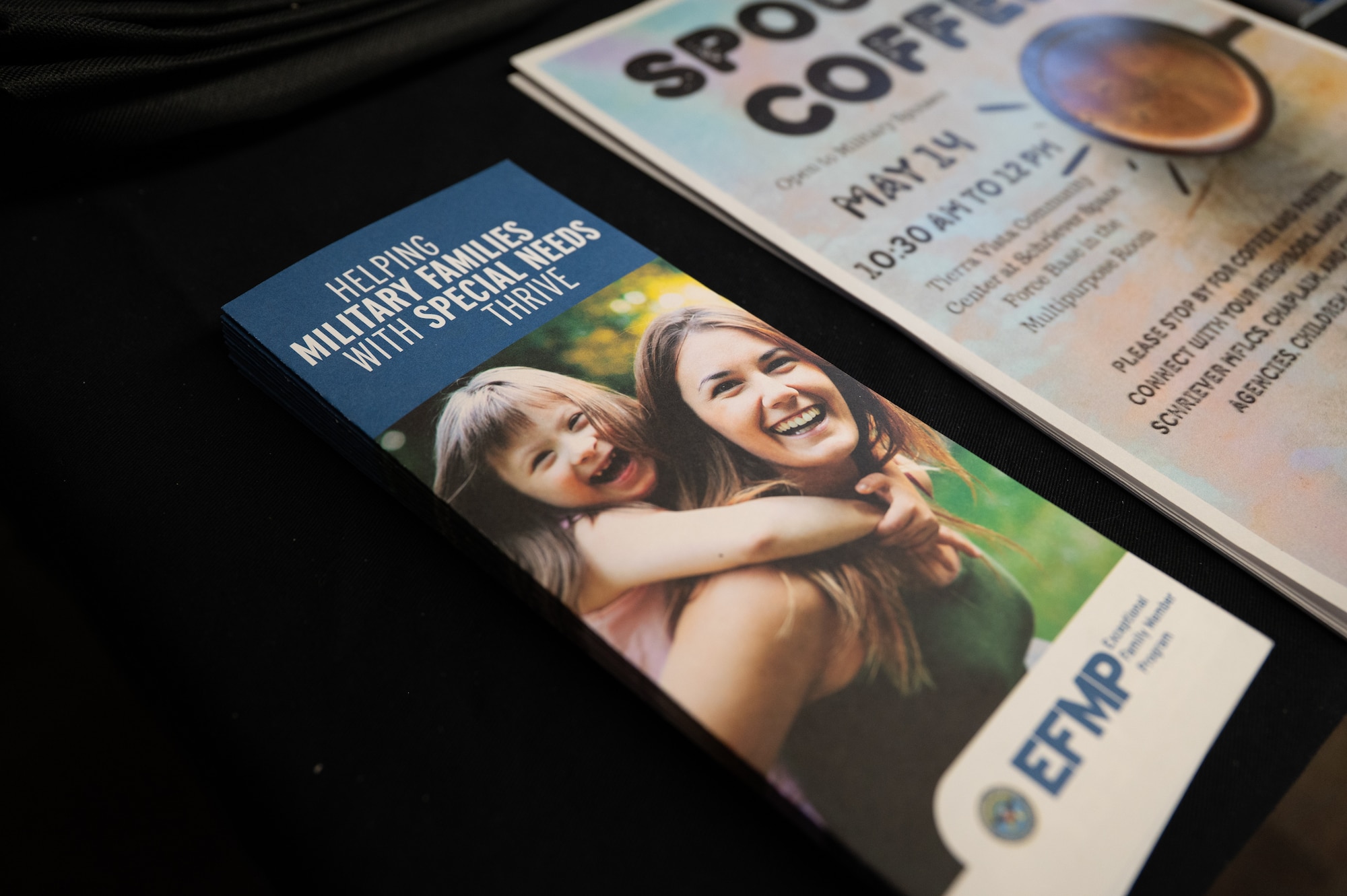 A military support flyer sits on a table displaying a happy mother and daughter.