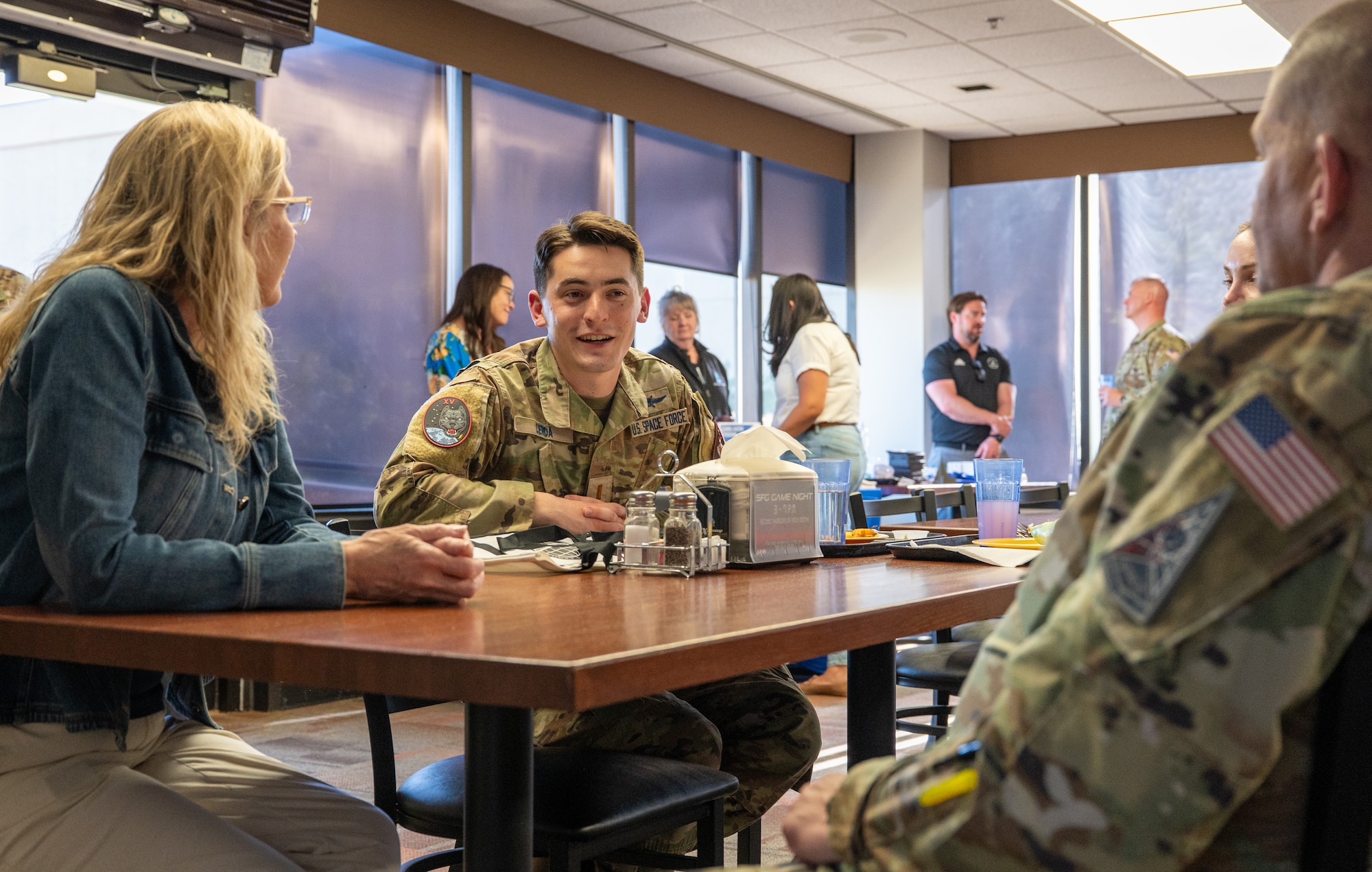 U.S. Space Force Guardian speaks with Air Force commander during the Commit Phase Family Dinner.