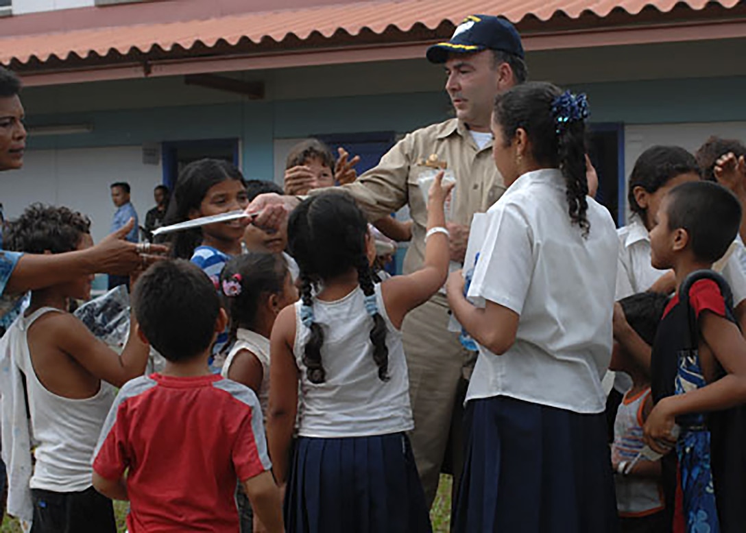 Capt. Bob Kapcio, Comfort mission commander, hands out school supplies to children at a local school in Corinto, Nicaragua, during a community relations project in support of the Military Sealift Command hospital ship USNS Comfort’s (T-AH 20) 2007 deployment. Comfort was on a four-month humanitarian deployment to Latin America and the Caribbean providing medical treatment to more than 98,000 patients in a dozen countries. Kapcio recently retired from federal service after serving 33 years in uniform and 14 years in a civilian role at U.S. Naval Forces Southern Command/U.S. 4th Fleet. Kapcio served as Mission Commander of the first Comfort deployment to the U.S. Southern Command region in more than 30 years in 2007, a mission now known as Continuing Promise 2007. U.S. Naval Forces Southern Command/U.S. 4th Fleet is the maritime component of U.S. Southern Command and the trusted maritime partner for Caribbean, Central and South America maritime forces leading to improved unity, security, and stability.