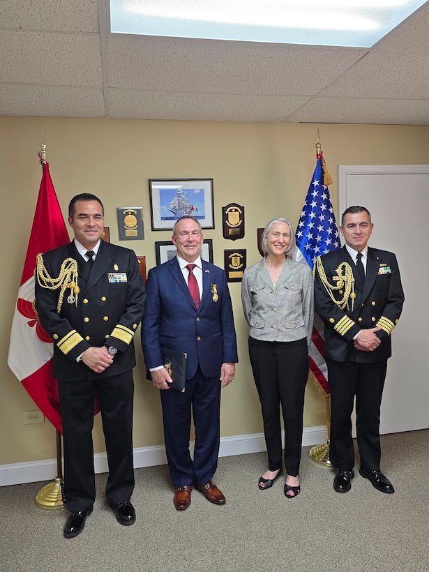 From left, Peru Navy Rear Adm. Oscar Oliva, Defense and Naval Attaché to the Embassy of Perú in the United States of America, Bob Kapcio, Patrice Kapcio, and Peru Navy Capt. Carlo Novoa, Deputy Naval Attaché to the Embassy of Perú in the United States of America, take photos following an award ceremony honoring Kapcio at the Peru Defense Attache Office in Washington, D.C., March 20.  On behalf of the Commander-In-Chief of the Peruvian Navy, Adm. Luis Polar, Rear Adm. Oliva awarded Kapcio the Naval Medal of Honor for Merit, which recognizes people who provide exceptional service through actions that contribute to enhancing the prestige and advancement of the Peruvian Navy. Kapcio recently retired from federal service after serving 33 years in uniform and 14 years in a civilian role at U.S. Naval Forces Southern Command/U.S. 4th Fleet. U.S. Naval Forces Southern Command/U.S. 4th Fleet is the maritime component of U.S. Southern Command and the trusted maritime partner for Caribbean, Central and South America maritime forces leading to improved unity, security, and stability.