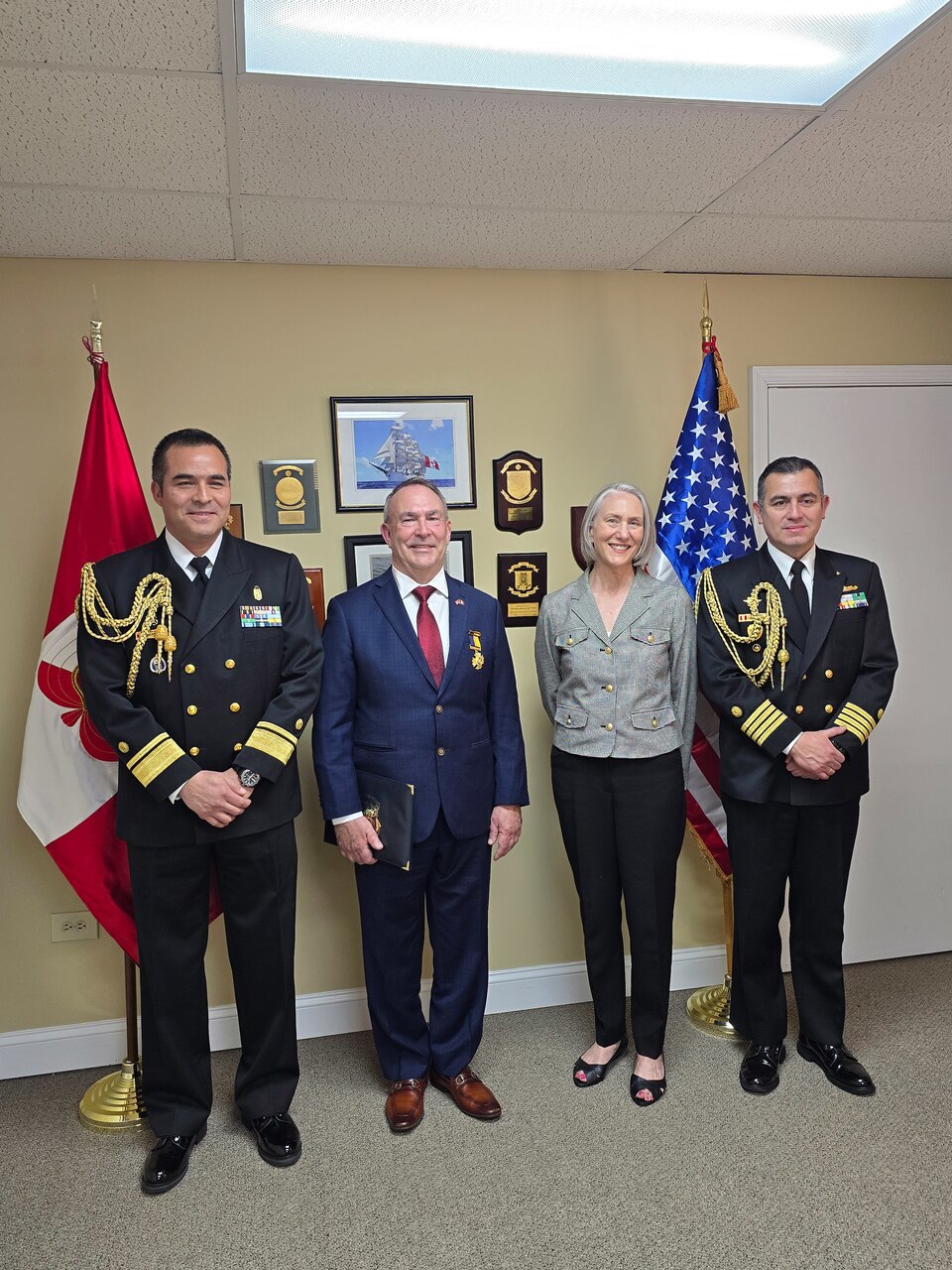 From left, Peru Navy Rear Adm. Oscar Oliva, Defense and Naval Attaché to the Embassy of Perú in the United States of America, Bob Kapcio, Patrice Kapcio, and Peru Navy Capt. Carlo Novoa, Deputy Naval Attaché to the Embassy of Perú in the United States of America, take photos following an award ceremony honoring Kapcio at the Peru Defense Attache Office in Washington, D.C., March 20.  On behalf of the Commander-In-Chief of the Peruvian Navy, Adm. Luis Polar, Rear Adm. Oliva awarded Kapcio the Naval Medal of Honor for Merit, which recognizes people who provide exceptional service through actions that contribute to enhancing the prestige and advancement of the Peruvian Navy. Kapcio recently retired from federal service after serving 33 years in uniform and 14 years in a civilian role at U.S. Naval Forces Southern Command/U.S. 4th Fleet. U.S. Naval Forces Southern Command/U.S. 4th Fleet is the maritime component of U.S. Southern Command and the trusted maritime partner for Caribbean, Central and South America maritime forces leading to improved unity, security, and stability.