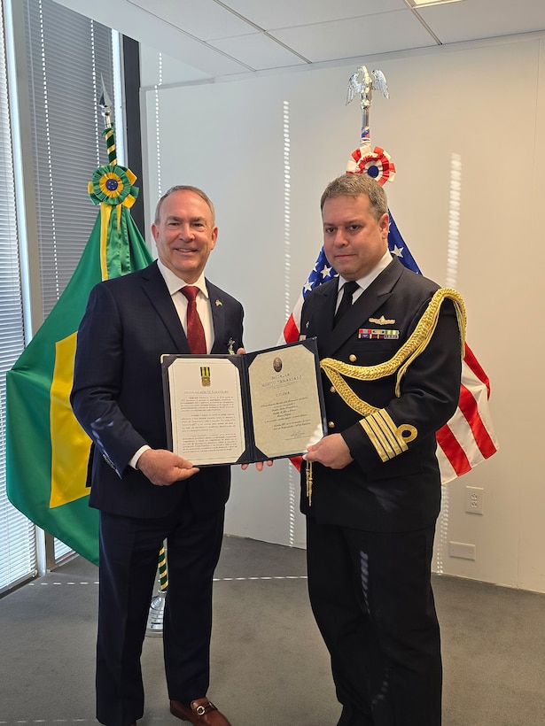 WASHINGTON, D.C. - (March 20, 2025) – Mr. Bob Kapcio, left, receives the Brazil Navy’s Tamandare Merit Medal from Brazil Navy Capt. Leonardo Mesquita, Deputy Naval Attaché to the Embassy of Brazil in the United States of America, at the Brazilian Embassy in Washington, D.C., March 20. On behalf of the Commandant of the Brazilian Navy, Adm. Marcos Olsen, Capt. Mesquita awarded Kapcio the medal, which honors Brazilian or partner nation individuals who demonstrate outstanding performance in promoting the traditions of the Brazilian Navy, honoring its deeds, or enhancing its historical figures. Kapcio recently retired from federal service after serving 33 years in uniform and 14 years in a civilian role at U.S. Naval Forces Southern Command/U.S. 4th Fleet. U.S. Naval Forces Southern Command/U.S. 4th Fleet is the maritime component of U.S. Southern Command and the trusted maritime partner for Caribbean, Central and South America maritime forces leading to improved unity, security, and stability.