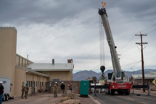U.S. Airmen and civilians from the 355th Civil Engineer Squadron as well as Airmen from the Air Force Civil Engineer Maintenance Inspection and Repair Team and civilian contractors prepare to move a new backup power generator into place at Davis-Monthan Air Force Base, Arizona, May 13, 2025.