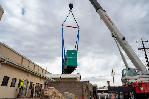 A civilian contractor operates a crane to move a new backup power generator into place at Davis-Monthan Air Force Base, Arizona, May 13, 2025.