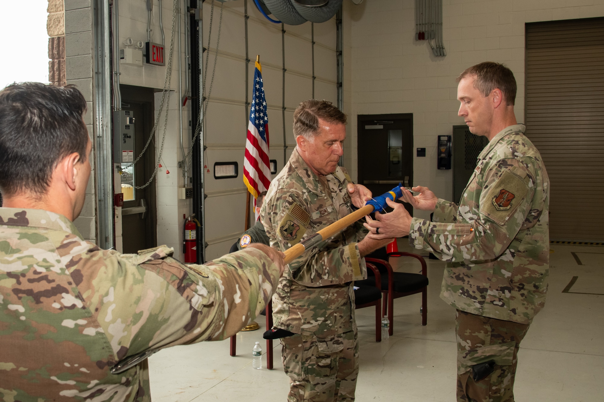 Photo of U.S. Air Force Lt. Col. Daniel Roske, 227th Air Support Operations Squadron (ASOS) commander, center, and Chief Master Sgt. Patrick Donohoe, 227th ASOS superintendent, right, fold the flag while Master Sgt.Victor Petrilli, 227th ASOS first sergeant, holds the guidon during a Casing of the Colors and Bronze Star Medal award ceremony at the 177th Fighter Wing, Egg Harbor Township, New Jersey, May 4, 2025. The Casing of the Colors Ceremony marks a transition of a unit, whether that be inactivation, relocation, or deployment. The Bronze Star is awarded to service members who distinguish themselves by heroic or meritorious achievement or service in a combat zone.