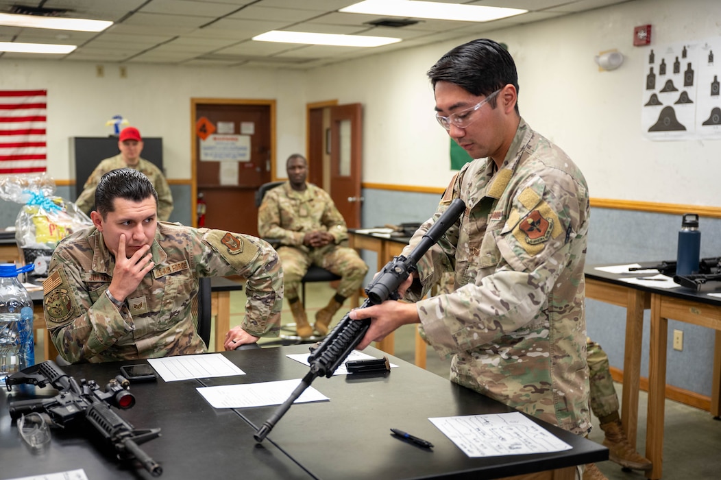 Members of the 56th and 944th Security Forces Squadrons watch as U.S. Air Force Staff Sgt. Casey Kaneshiro, 309th Aircraft Maintenance Unit weapons load crew member, disassembles an M4 carbine during a manipulation competition for National Police Week, May 14, 2025, at Luke Air Force Base, Arizona.