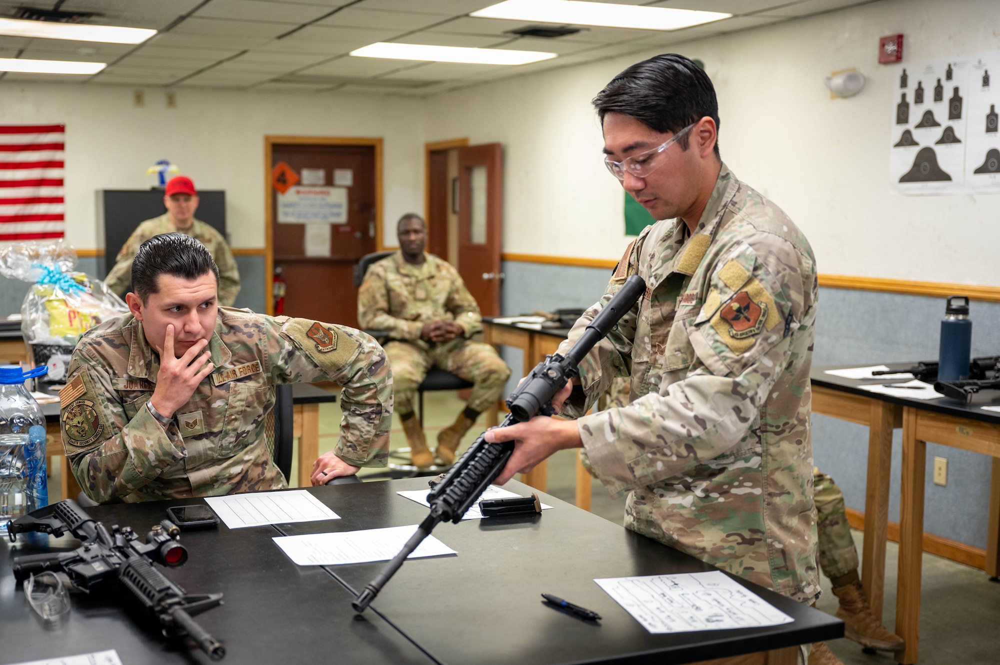 Members of the 56th and 944th Security Forces Squadrons watch as U.S. Air Force Staff Sgt. Casey Kaneshiro, 309th Aircraft Maintenance Unit weapons load crew member, disassembles an M4 carbine during a manipulation competition for National Police Week, May 14, 2025, at Luke Air Force Base, Arizona.