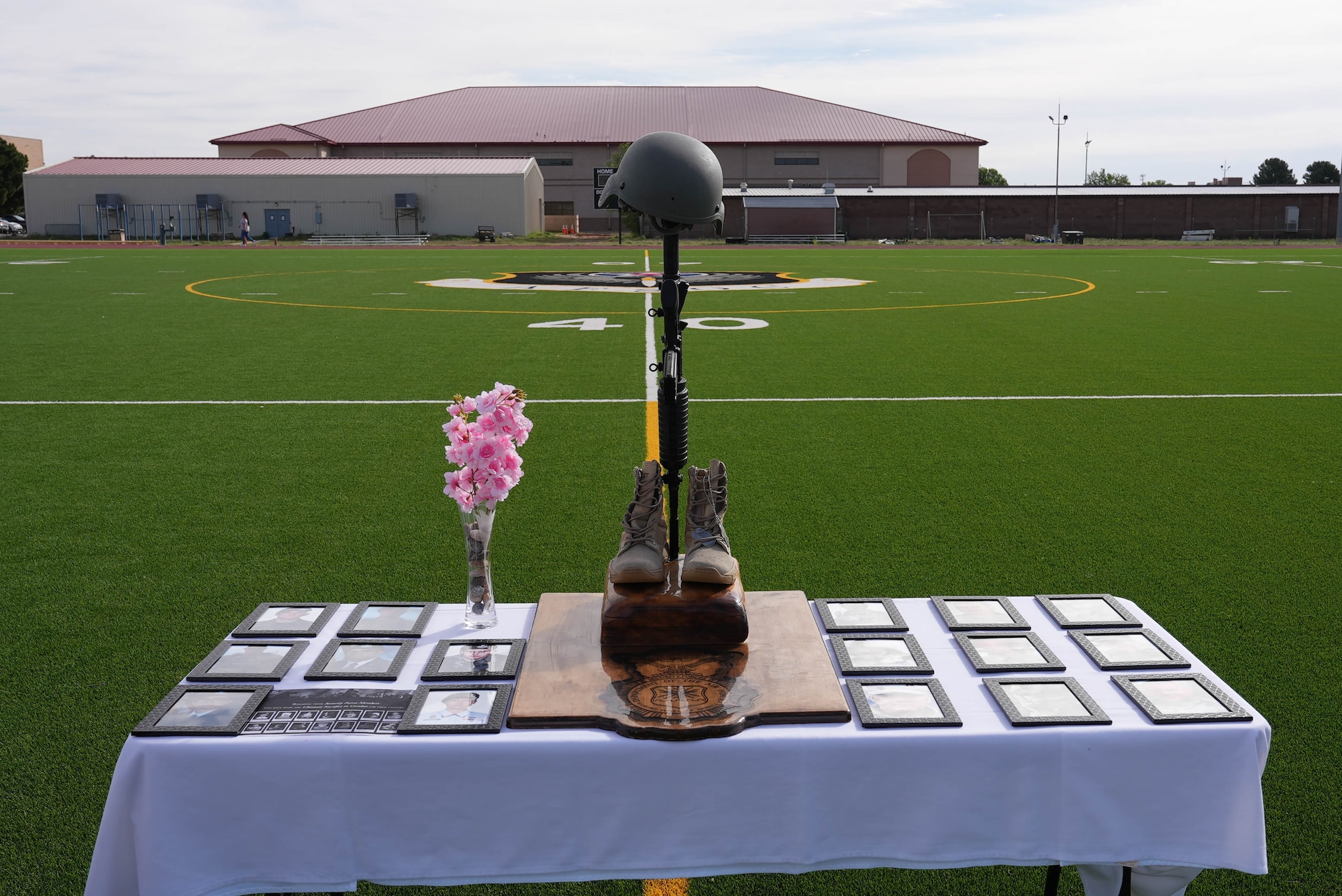 A battlefield cross stands over portraits of the U.S. Air Force Security Forces Airmen and a Clovis Police Department officer, all of whom have fallen in the line of duty since the beginning of the 21st century at Cannon Air Force Base, New Mexico, May 15, 2025. Security Forces Airmen assigned to the 27th Special Operations Wing held a 24-hour vigil in honor of fallen law enforcement officers. (U.S. Air Force photo by Staff Sgt. Kevin Williams)