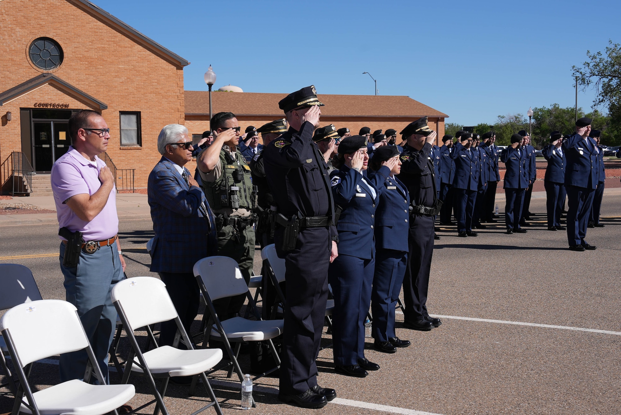 Leaders of local law enforcement agencies and the U.S. Air Force Airmen assigned to the 27th Special Operations Wing salute during the National Anthem during the closing ceremony of National Police Week at Cannon Air Force Base, New Mexico, May 16, 2025. The 27th SOW values the cooperative relationship between Security Forces and the law enforcement agencies that serve the local Cannon community. (U.S. Air Force photo by Staff Sgt. Kevin Williams)