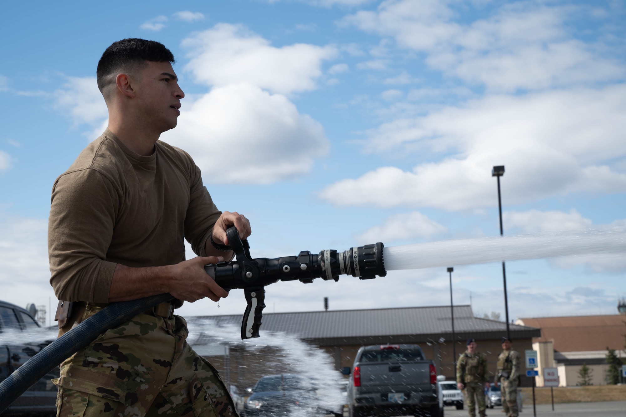 U.S. Air Force Senior Airman Ricardo Balleza, 354th Civil Engineering Squadron fireman, uses a fire hose during the Battle of the Badges at Eielson Air Force Base, Alaska, May 13, 2025.