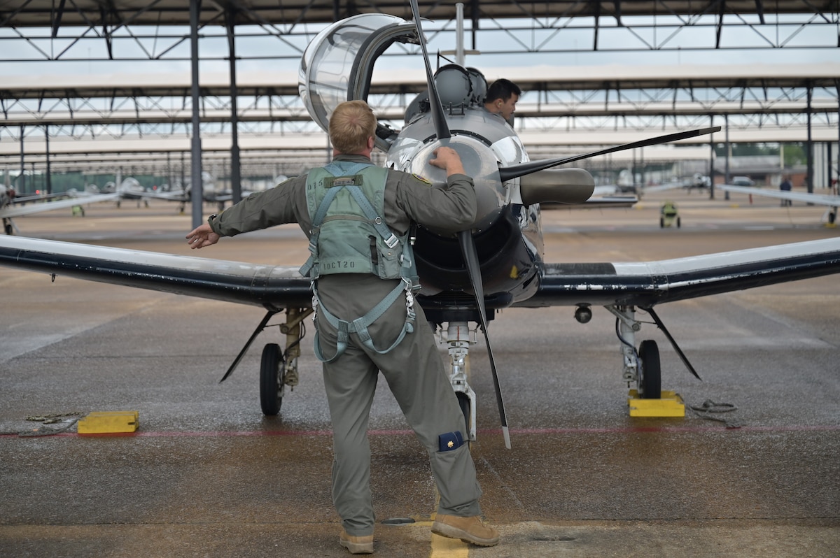 A 43rd Flying Training Squadron instructor pilot examines a T-6A Texan II before flight.