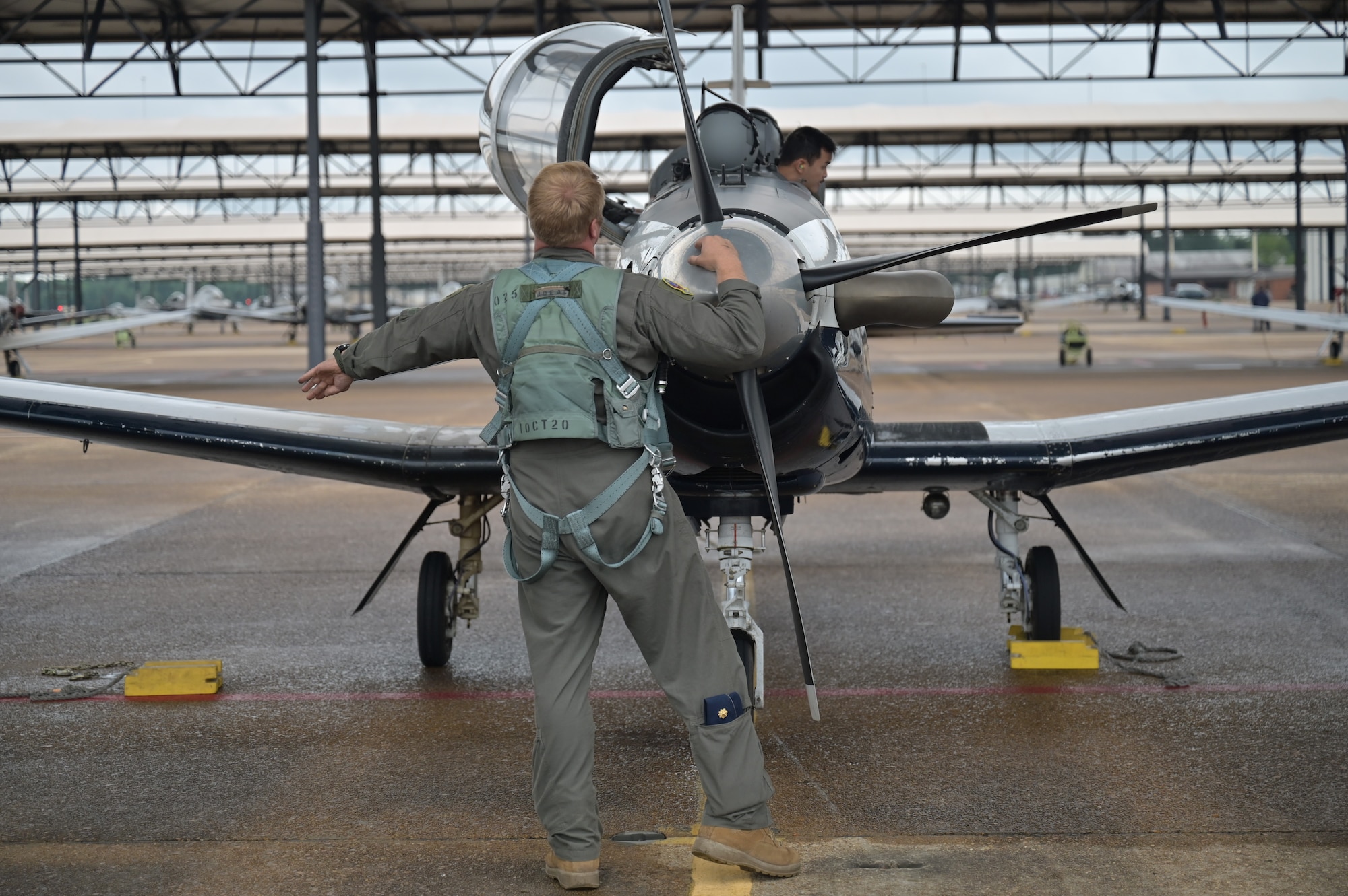 A 43rd Flying Training Squadron instructor pilot examines a T-6A Texan II before flight.