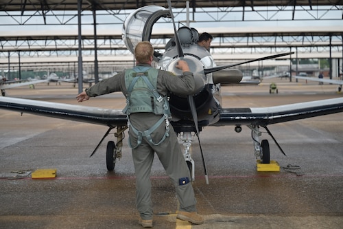 A 43rd Flying Training Squadron instructor pilot examines a T-6A Texan II before flight.