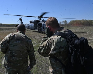 Airmen assigned to the 175th Wing, Maryland Air National Guard, prepare to board a HH-60W Jolly Green II helicopter during combat search and rescue training at the Hardwood Range, Wisconsin, May 12, 2025. The HH-60W Jolly Green II helicopter was part of the Combat Search and Rescue task force element during the week-long training. (U.S. Air National Guard photo by Senior Master Sgt. Chris Schepers)