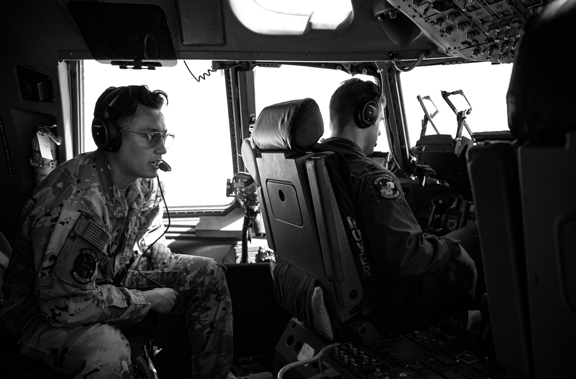U.S. Air Force Capt. Keanu Komar, left, 3rd Airlift Squadron pilot, talks to pilots aboard a C-17 Globemaster III during a Leadership Central Delaware orientation flight near the U.S. East Coast, May 15, 2025. The LCD program, operated by the Central Delaware Chamber of Commerce, visits Dover AFB annually to gain better understanding of base operations and to build community ties with the Air Force. (U.S. Air Force photo by Staff Sgt. Marco A. Gomez)