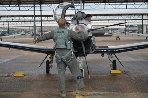 A 43rd Flying Training Squadron instructor pilot examines a T-6A Texan II before flight.