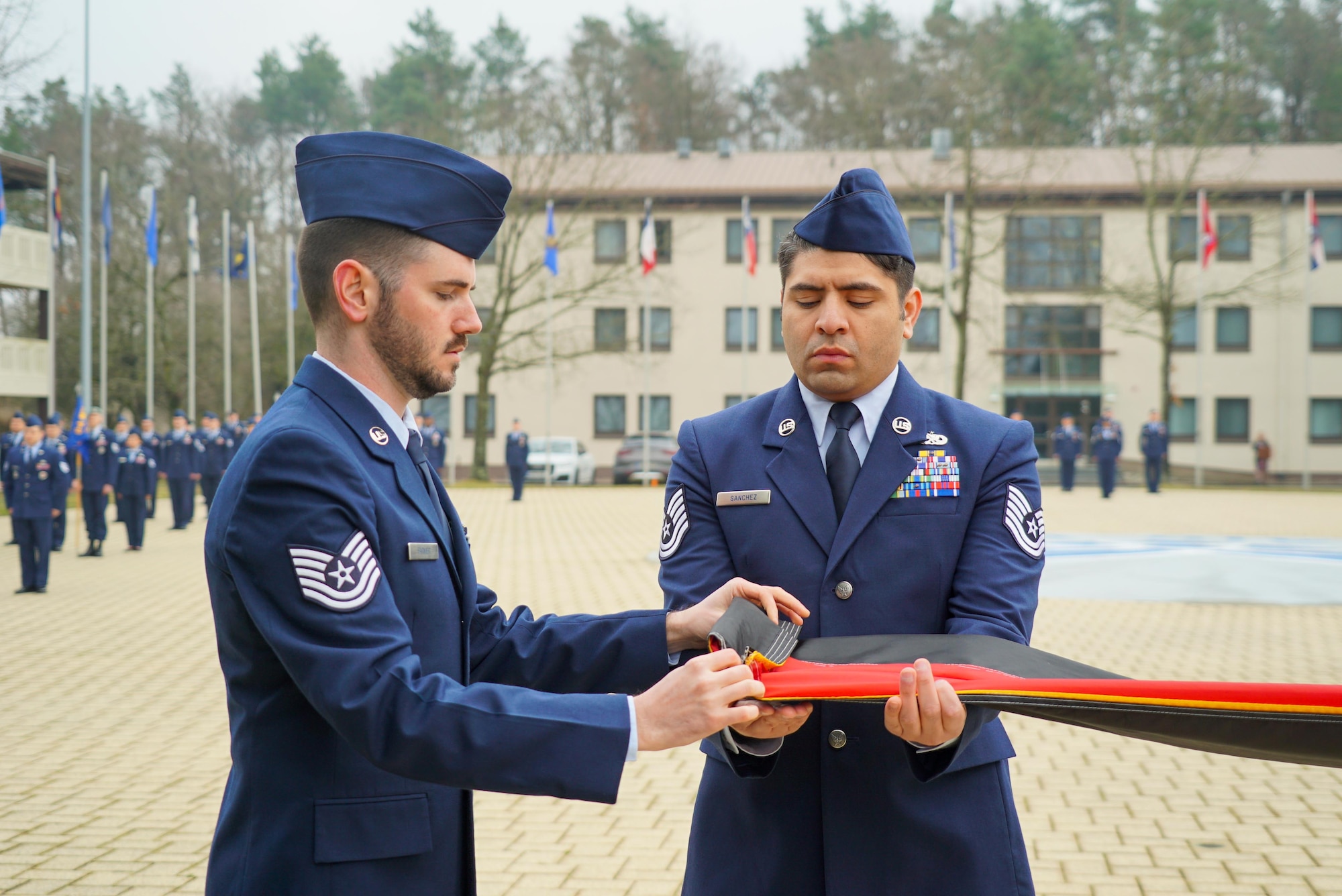 Students fold a German flag during a retreat ceremony